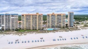 A beachfront hotel with multiple high-rise buildings, a sandy beach, and a pool area. - Summer House Condo 503B (Orange Beach)