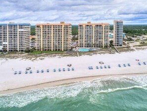 Ein Strandhotel mit mehreren Hochhäusern, einem Sandstrand und einem Poolbereich.