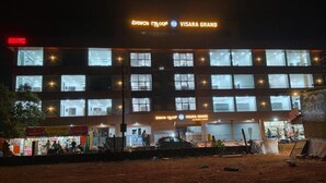 Un edificio de varios pisos con letreros que indican 'VISARA GRAND' y 'HOTEL'.