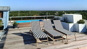 A rooftop terrace with lounge chairs, a swimming pool, and a view of the city and forest. - SUPERB T4 SEAFRONT WITH ROOFTOP IN ST JEAN DE MONTS (Saint-Jean-de-Monts)