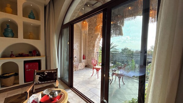 A spacious room with a large sliding glass door leading to an outdoor patio with a table and chairs. - Tal Rumman Hotel (Al Rumman)