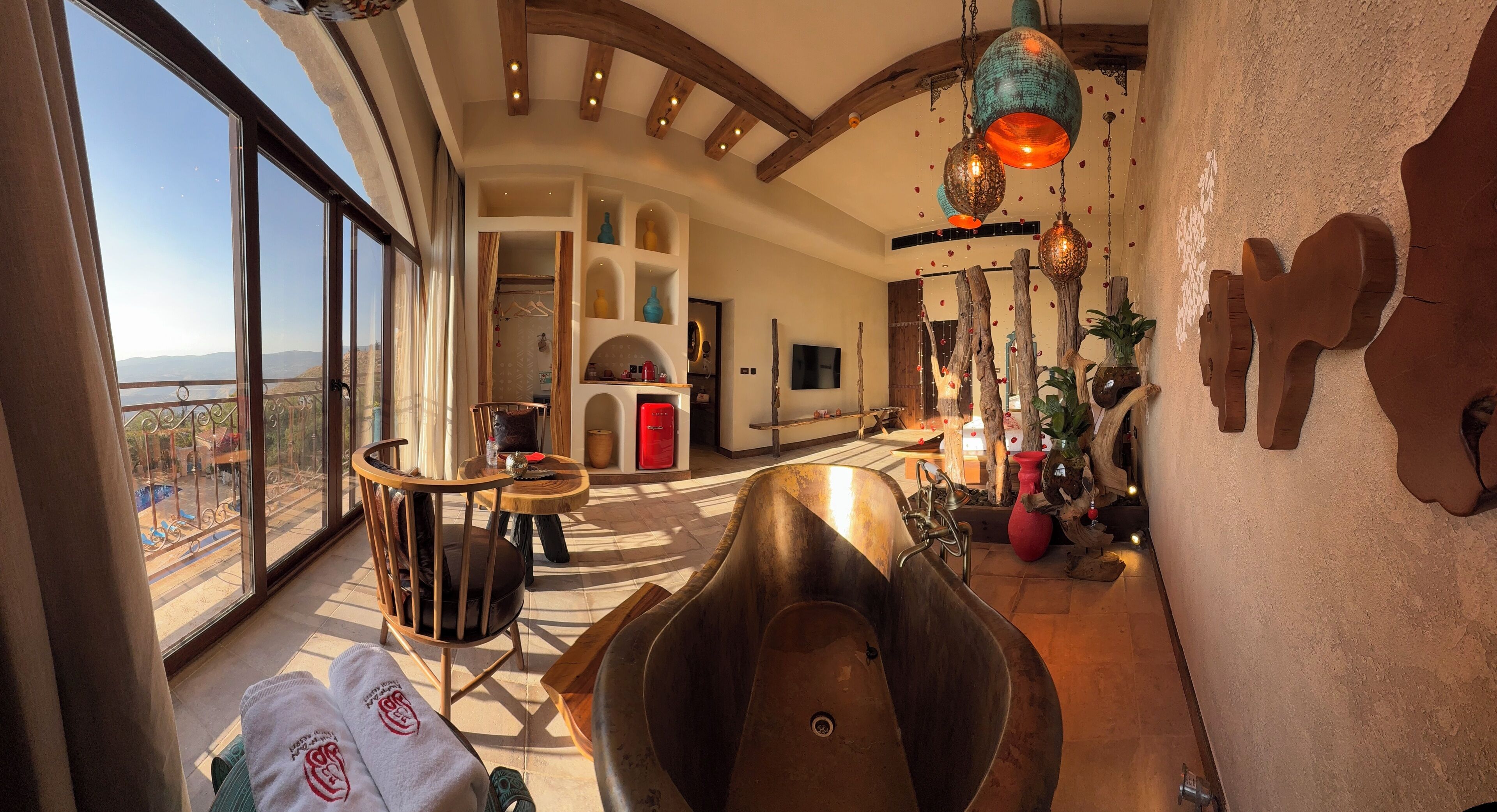 Un espacio habitable amplio con una bañera grande, una mesa de comedor y vistas al exterior.