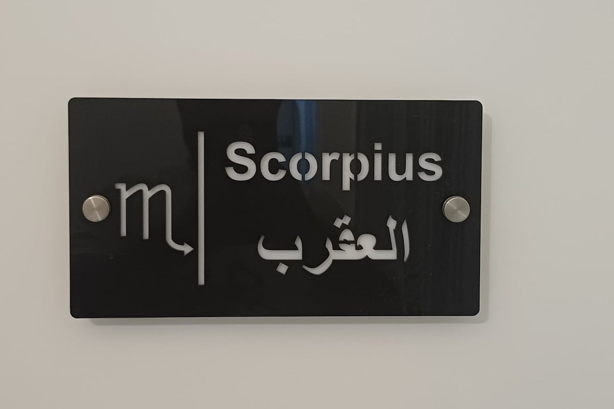 A black sign with 'Scorpio' and 'المقرب' written on it.