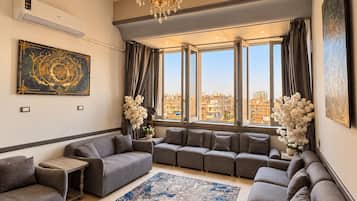 A modern living room with a sectional sofa, a small table, and a large window with curtains.