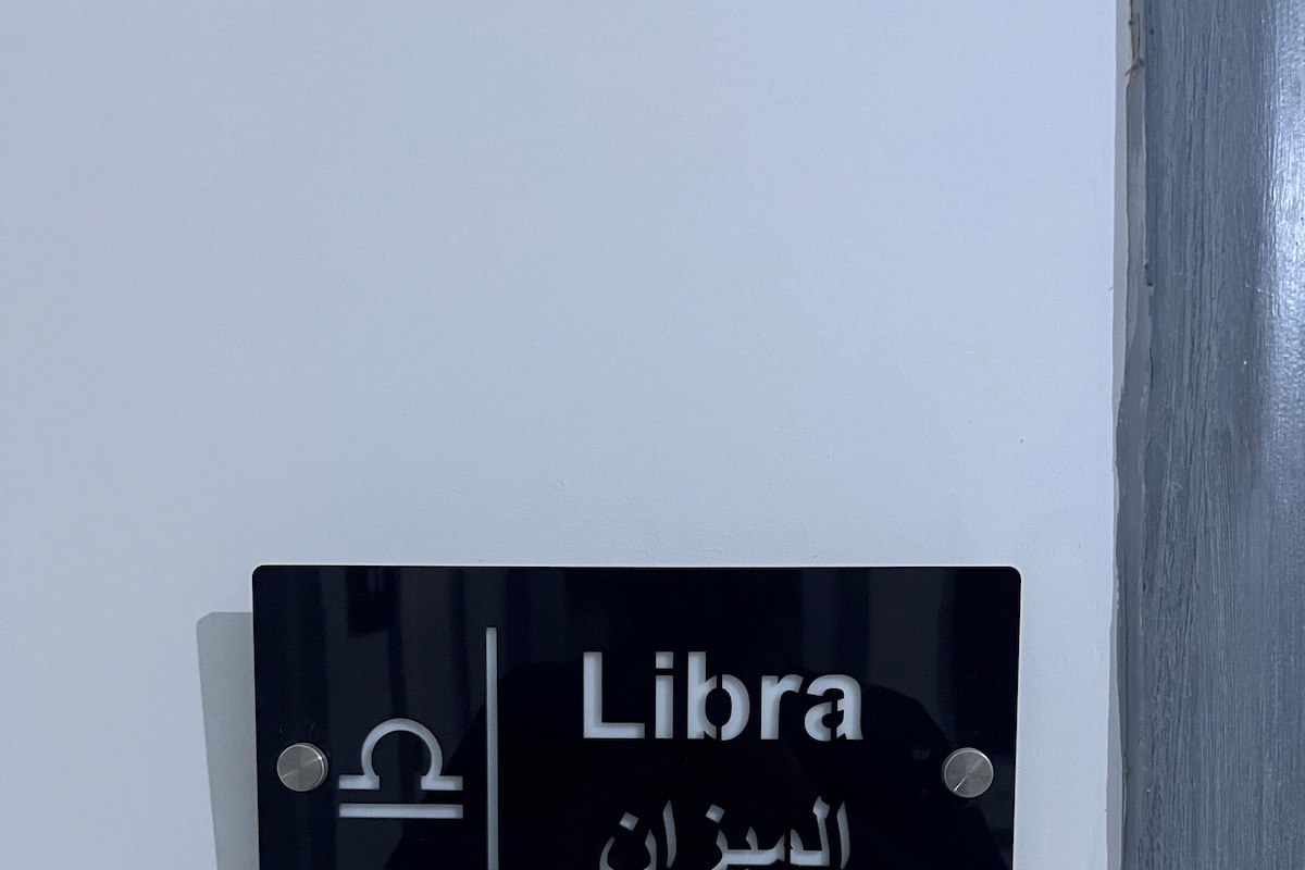 A black sign with white text reading 'Libra' and Arabic script below it.