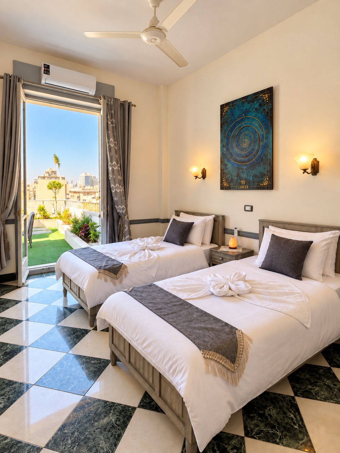 A hotel room with two beds, a ceiling fan, a painting, and a view of the city.