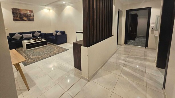 Una sala de estar moderna con un sofá, una mesita de centro y un panel decorativo en la pared.