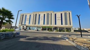 Un edificio moderno con fachada simétrica, ventanas amplias y una entrada central.