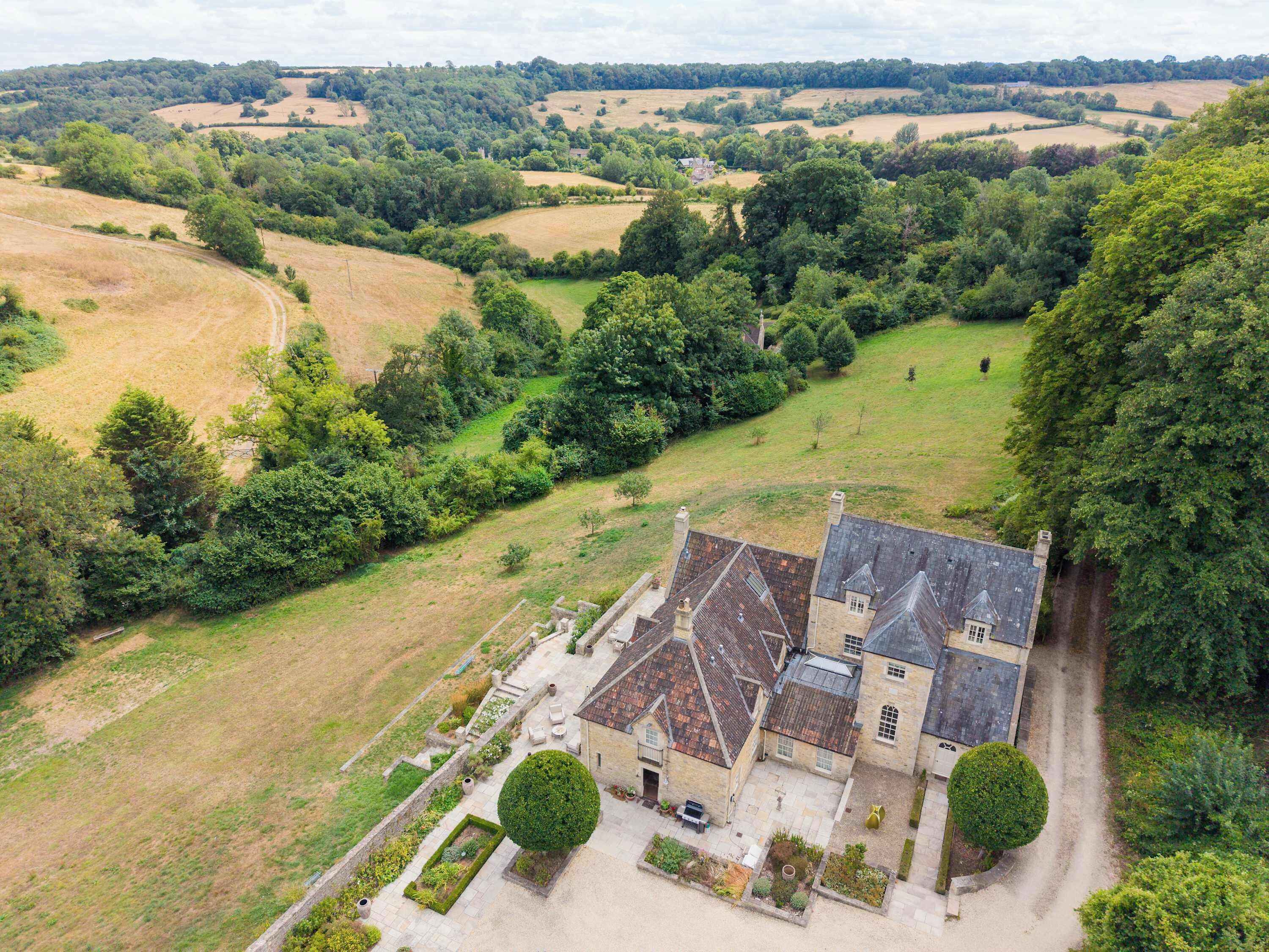 A large estate with a main building, multiple outbuildings, and expansive surrounding fields.