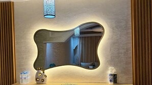 Ett badrumsskåp med en spegel, en hängande lampa och toalettartiklar på bänkskivan.