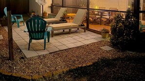 Ein Terrassenbereich im Freien mit Lounge-Möbeln, einem Tisch und Lichterketten.