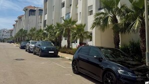 A row of modern multi-story buildings with parking spaces in front. - Magnificent sea & golf views. Pools, Terraces (Asilah)