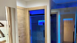 Ein modernes Interieur mit Glastür zum Duschbereich, Holzvertäfelung und Fliesenboden.