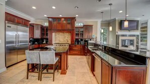 Una cocina moderna con armarios de madera, electrodomésticos de acero inoxidable y una isla central.