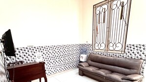 A reception area with a reception desk, a sofa, a chair, and a decorative metal gate.
