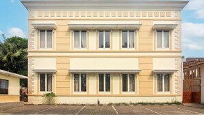 A two-story building with a symmetrical facade, large windows, and a flat roof.