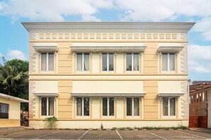 A two-story building with a symmetrical facade, large windows, and a flat roof.