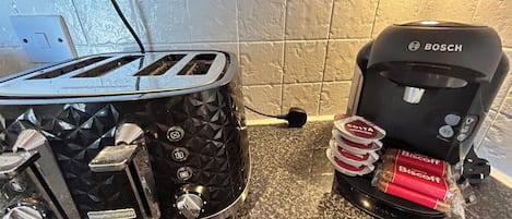Una cocina con un tostador y una cafetera sobre la encimera.