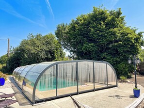 A transparent greenhouse structure with a curved roof, surrounded by trees and a clear sky. - Two gîtes in the countryside for 25 people: indoor swimming pool and play areas (Montrevault-sur-Èvre)