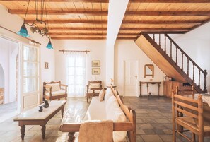 Ein Wohnzimmer mit Holzboden, einer Couch, einem Tisch und einer Treppe.