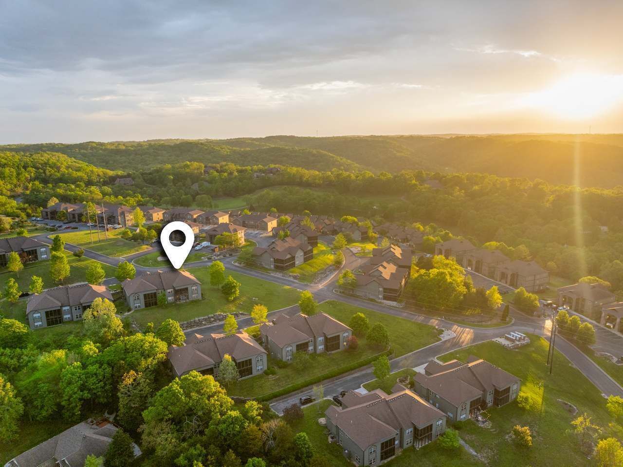 An aerial view of a residential area with houses, roads, and greenery.