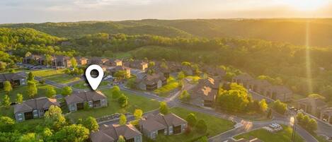 An aerial view of a residential area with houses, roads, and greenery.