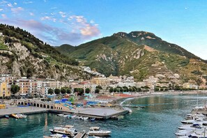 A coastal town with a marina, terraced vineyards, and a prominent mountain in the background. - Cozy Apartment nestled in a fantastic lemon grove. (Maiori)