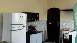 Uma cozinha com geladeira, cafeteira e fogão.