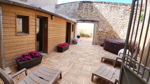 Ein Holzgebäude mit einer Steinwand, einem Grill und Sitzgelegenheiten im Freien.