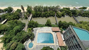 Eine Luftaufnahme eines Resorts mit Schwimmbad, Strand und einer Pier.