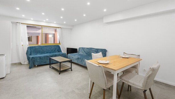 A modern room with a dining table, two sofas, a small table, and a window with curtains. - 🏡 Charming renovated 2-room apartment - Ideal location behind the Martinez in Cannes (Cannes)