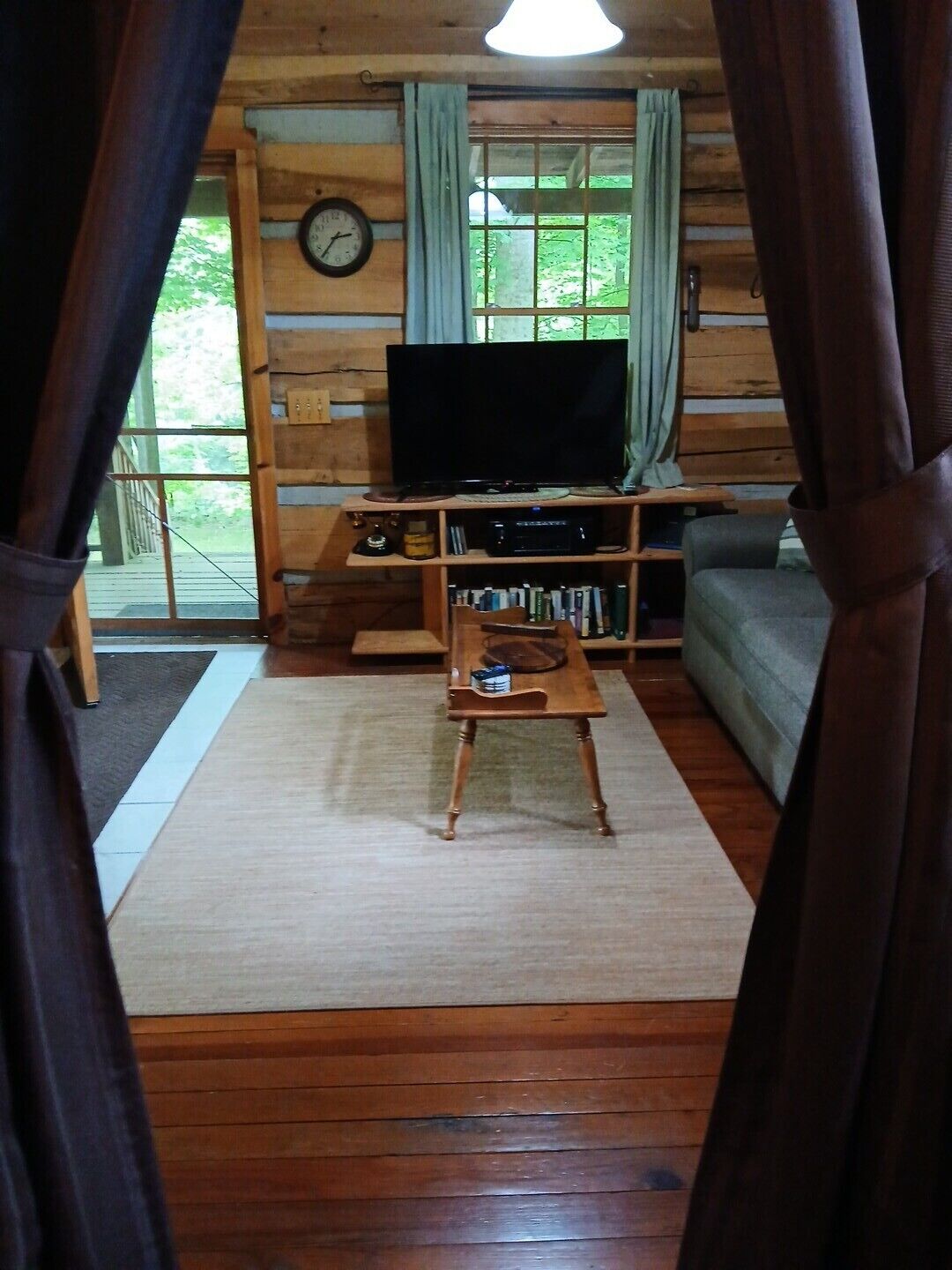 Un intérieur en bois avec une télévision, une bibliothèque et un canapé.
