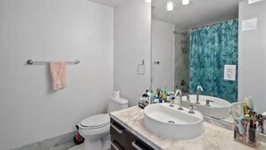 Ein modernes Badezimmer mit Toilette, Waschbecken und Dusche.