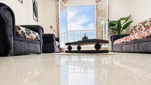 Una sala de estar con dos sofás, una mesa de centro y un ventanal.