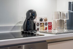 A kitchen with a coffee machine, two glasses, and boxes of coffee and tea. - Modern & Cosy 1 Bedroom Flat | Sleeps 6 (London)
