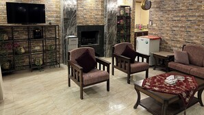 A living room with a TV, fireplace, and seating area. - Secluded Hilltop Villa Near Ancient Jarash — Privacy, Views & Pure Tranquility (Jerash)