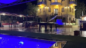 A multi-story building with balconies, a pool area, and outdoor seating. - Secluded Hilltop Villa Near Ancient Jarash — Privacy, Views & Pure Tranquility (Jerash)