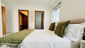A bedroom with a bed, a window, and a door leading to another room. - 3 BEDROOMS AND TWO BATHROOMS, CLOSE TO DOWNTOWN, WITH 2 SWIMMING POOLS IN THE COMMON AREA. (Punta Cana)