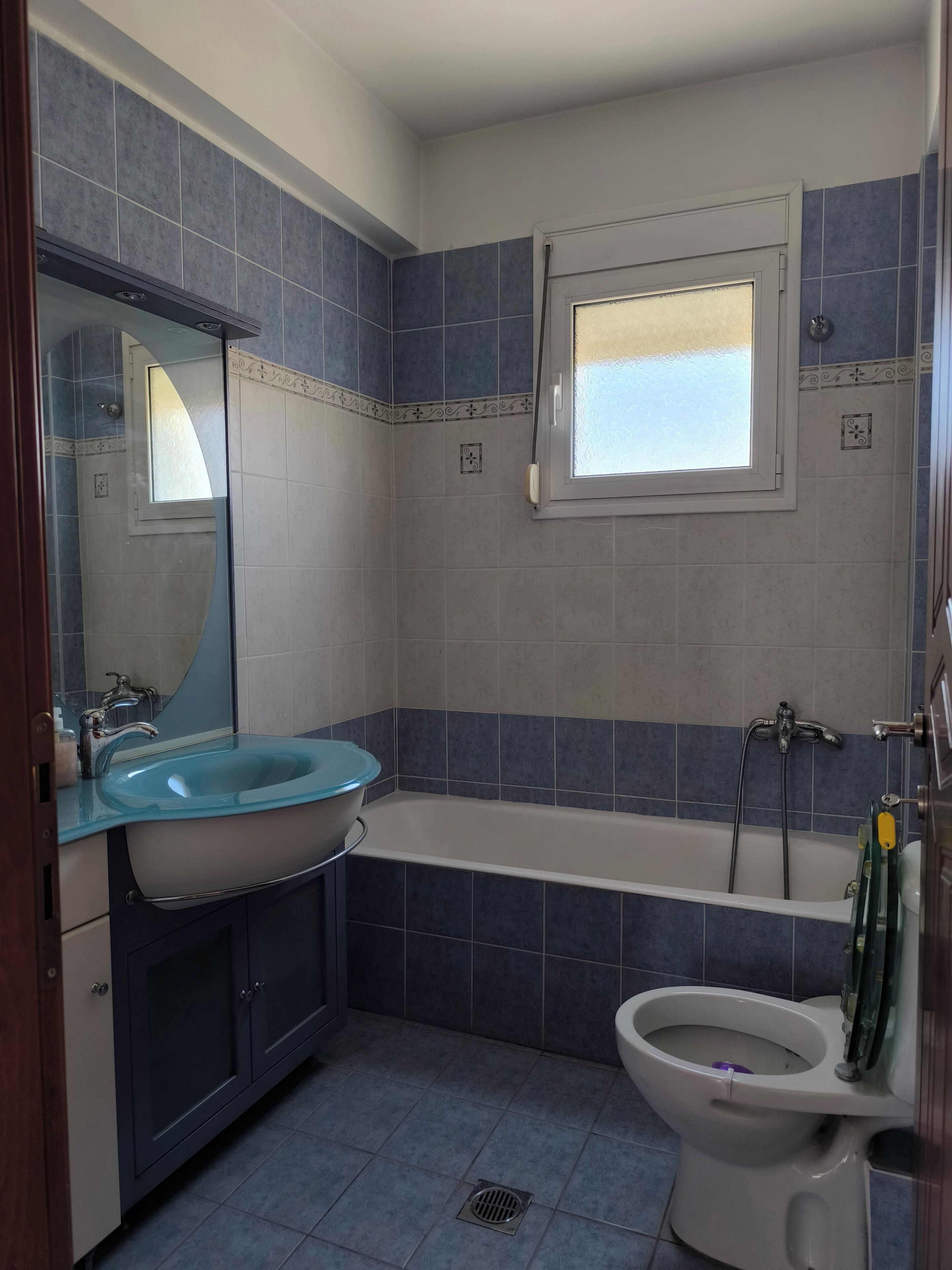 Een badkamer met een wastafel, toilet en bad.