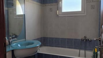Een badkamer met een wastafel, toilet en bad.