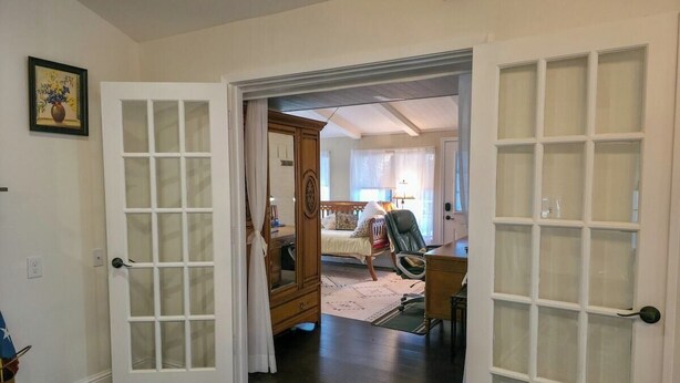 A room with a bed, a chair, a desk, and a wardrobe.