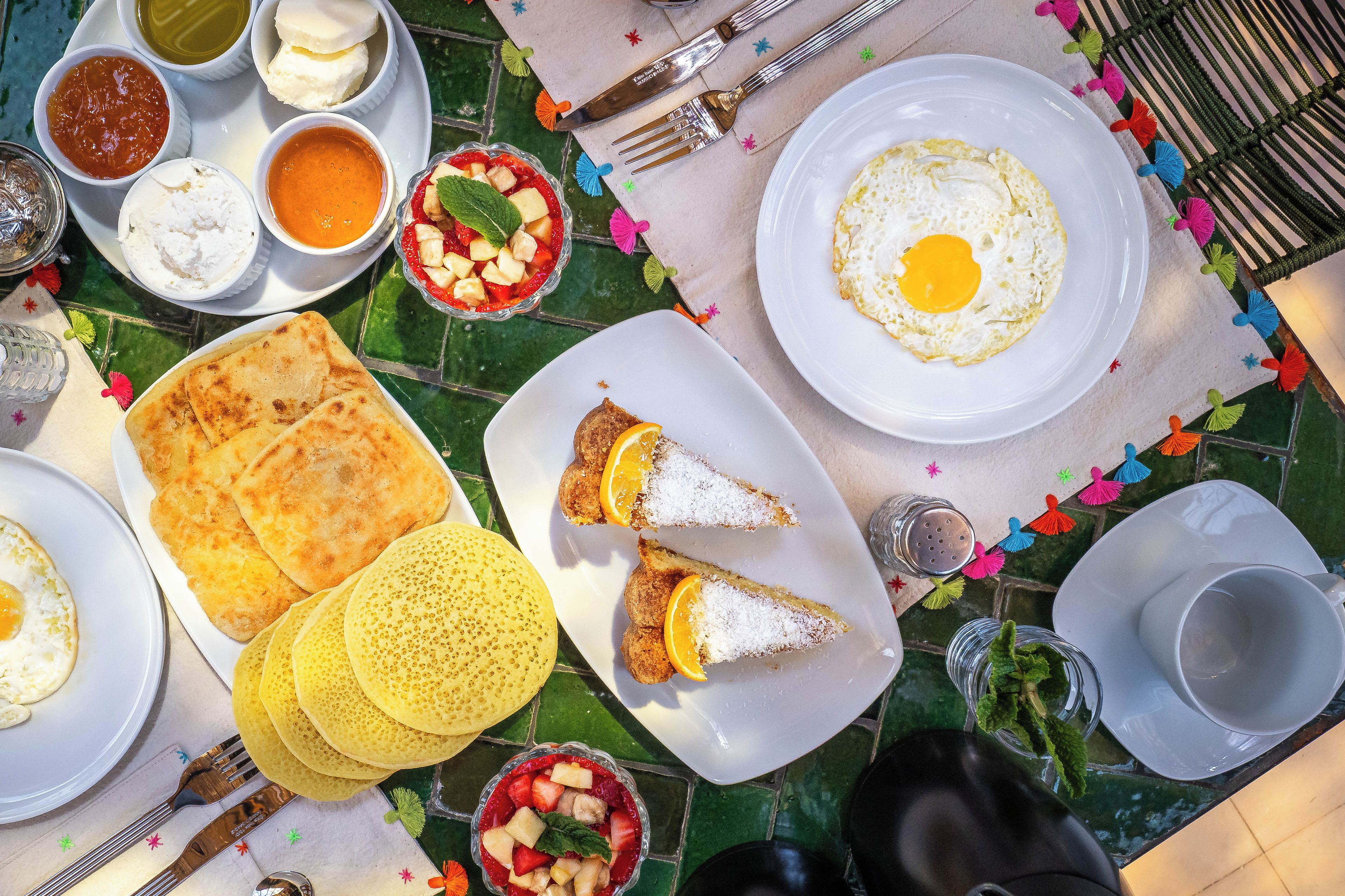 Ein Tisch reichhaltig gedeckt mit Frühstücksartikeln, darunter Eier, Toast und Obst.