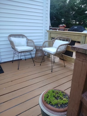 En terrasse med fletstole og en plantekasse.