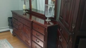 A wooden dresser with multiple drawers and a mirror.