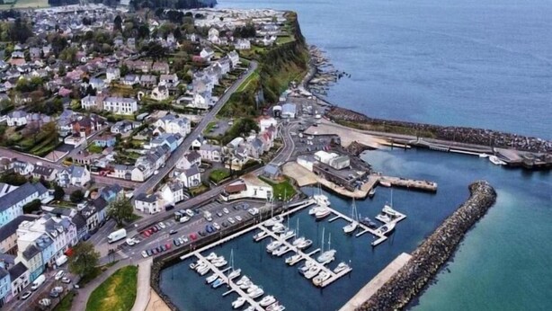 An aerial view of a coastal town with a marina, residential area, and a rocky breakwater. - Church View  (Ballycastle)