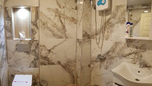 A bathroom with a marble shower, a toilet, a sink, and a mirror. - Sevimli suit konaklama (Amasra)