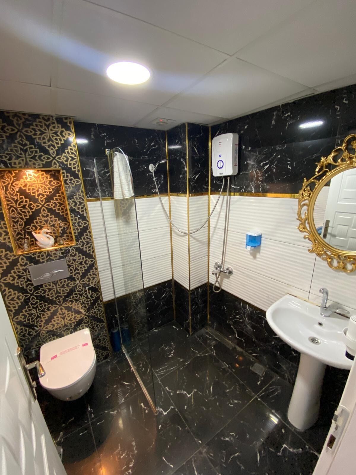 Une salle de bain avec une douche, des toilettes et un lavabo.