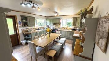 A kitchen with a dining table, chairs, and a refrigerator.