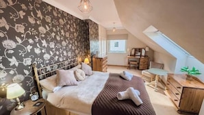 A bedroom with a bed, bedside table, lamp, and a dresser. - Spacious Family Retreat with Stunning Loch Views near Portree (Portree)