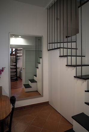 A staircase with black railings and a door leading to another room. - Nest by the Medici Chapels - Attico (Firenze)